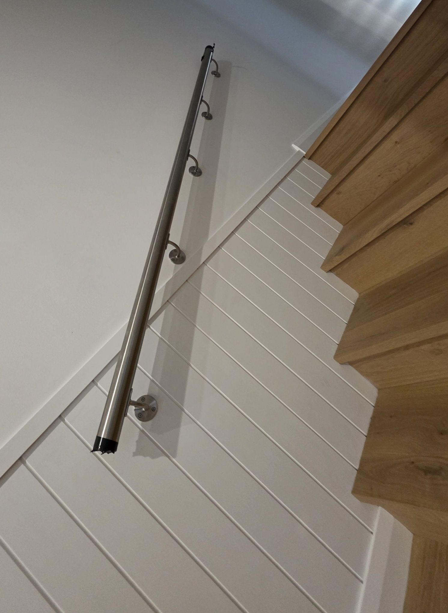 A stainless handrail fitted to a timber staircase by Soley's