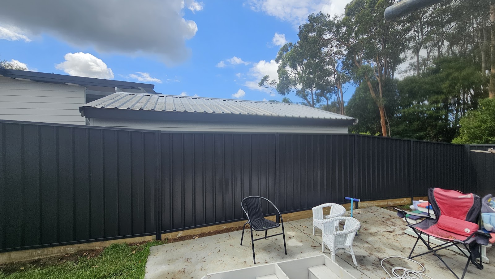 New dark steel fence around a backyard slab
